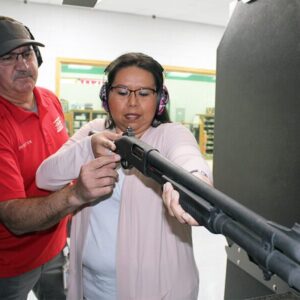 A man and woman shooting a shotgun together in Oklahoma City.
